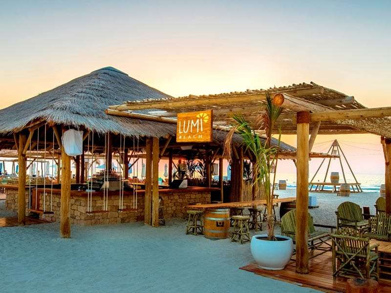 Lumi Beach Bar at Umm Al Quwain Hotel and Resort with an Africa thatch roof.