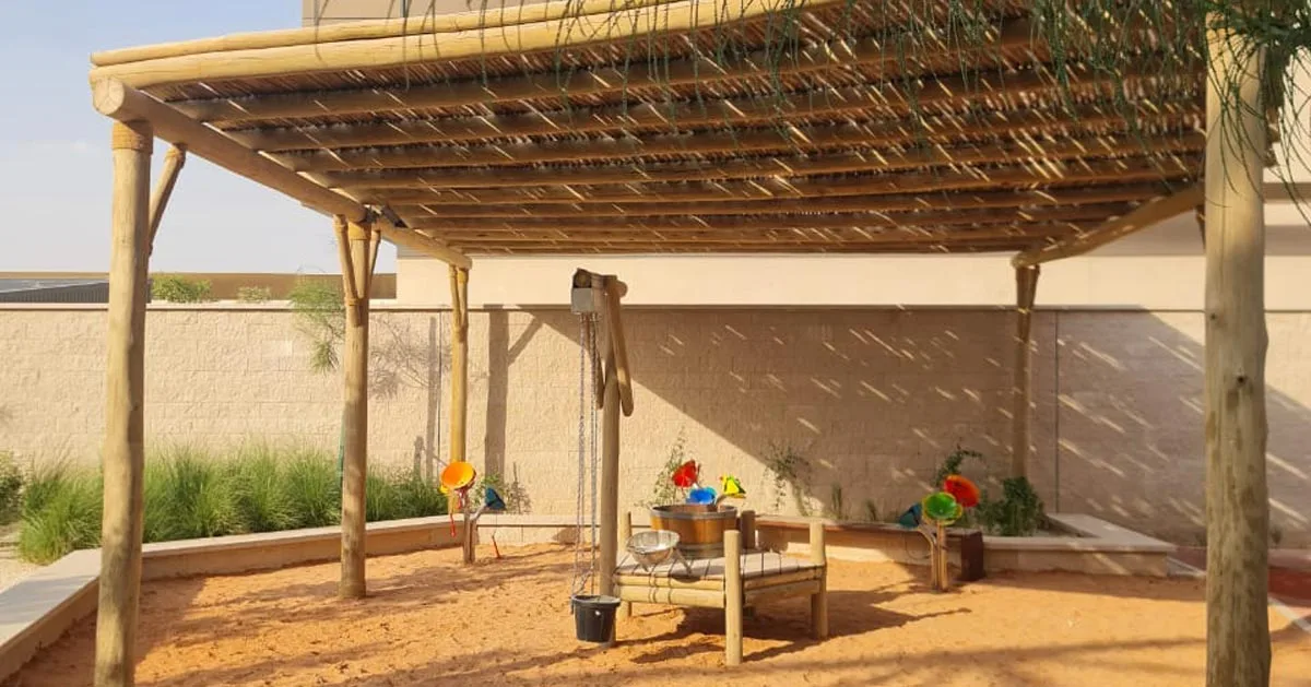 Eco-friendly timber play structures blending with nature at Misk School, Saudi Arabia.