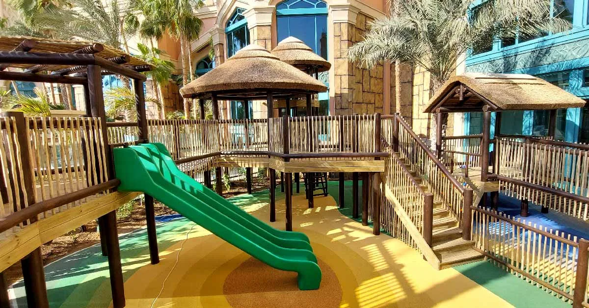 Children enjoying a sustainable timber play structure at the Explorer’s Club outdoor play area in Atlantis The Palm, Dubai.